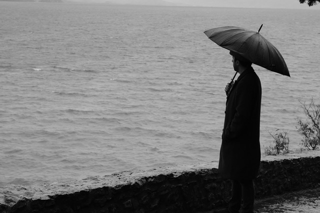 Contemplative Man with Umbrella by Sea (sumber: pexels.com)