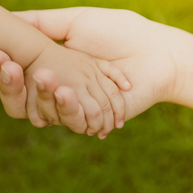 Photo: Adult hand grabbing baby hand. Source: Freepik.