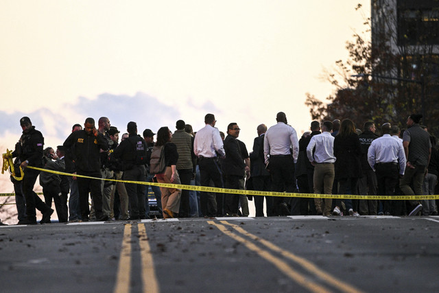Petugas penegak hukum mengunjungi lokasi kejadian penembakan di pusat kota Washington, Amerika Serikat, Rabu (26/11/2025). Foto: Brendan Smialowski/AFP