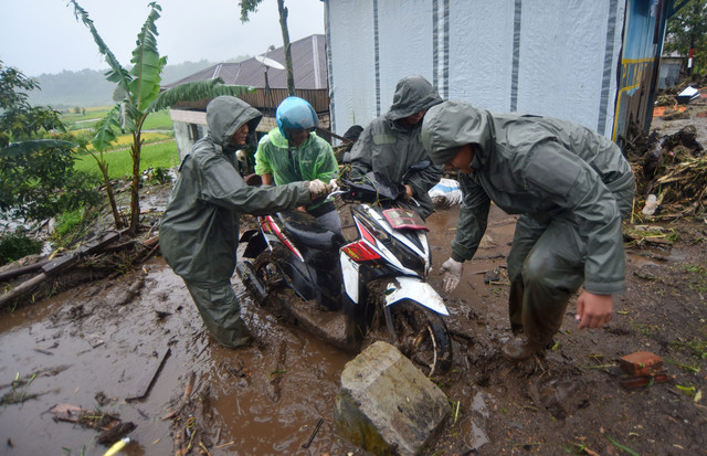Petugas Brimob Polda Sumbar membantu warga mengevakuasi motor di Toboh Tangah, Nagari Malalak Timur, Agam, Sumatera Barat, Kamis (27/11/2025). Foto: Iggoy el Fitra/ANTARA FOTO