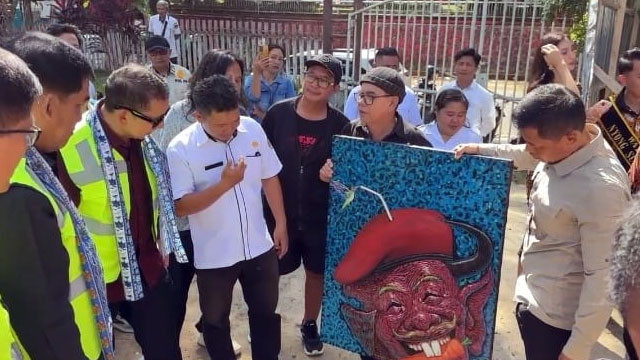 Menteri Kebudayaan, Fadli Zon, memperhatikan lukisan yang diberikan oleh para pegiat seni di Sulawesi Utara.