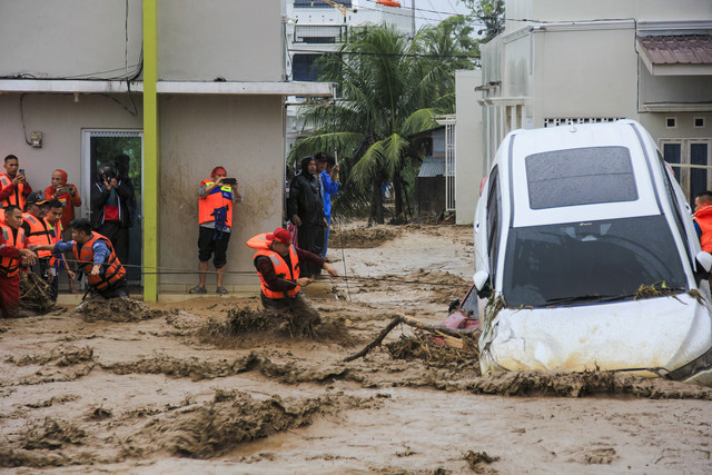 Tim penyelamat berusaha mengevakuasi warga yang terjebak banjir di rumah mereka, Padang, Sumatera Barat, Kamis (27/11). Foto: REZAN SOLEH / AFP