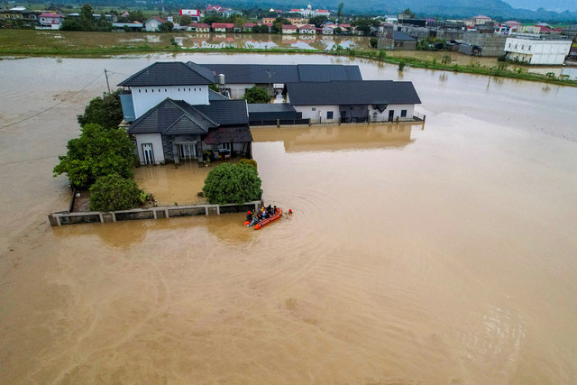 Tim penyelamat menggunakan perahu karet untuk mengevakuasi warga di permukiman yang terdampak banjir setelah hujan deras di Meureudu, Kabupaten Pidie Jaya, Provinsi Aceh, Indonesia, 27 November 2025 Foto: REUTERS/Hidayatullah Tajuddin