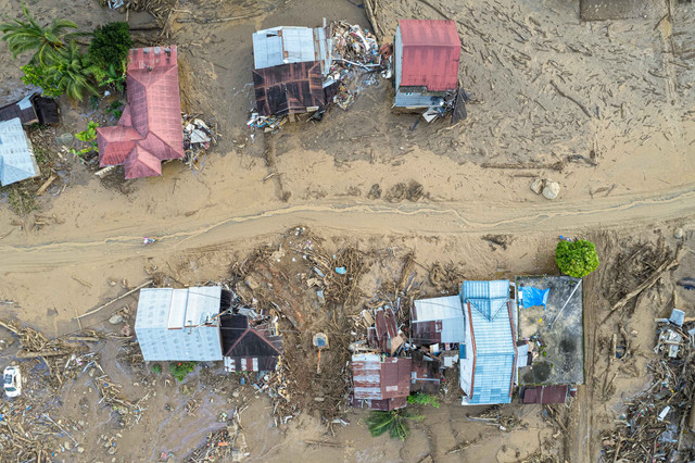 Foto udara warga melintas di permukiman Jorong Kayu Pasak yang rusak akibat banjir bandang di Nagari Salareh Aia, Palembayan, Agam, Sumatera Barat, Minggu (30/11/2025). Foto: Wahdi Septiawan/ANTARA FOTO