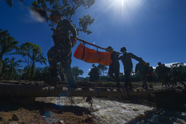Prajurit Batalyon TP 897/Singgalang dan Brimob Polda Sumbar mengevakuasi korban meninggal akibat banjir bandang di Jorong Kayu Pasak Selatan, Nagari Salareh Aia, Palembayan, Agam, Sumatera Barat, Senin (1/12/2025). Foto: Wahdi Septiawan/ANTARA FOTO