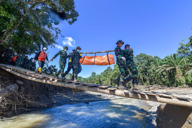 Prajurit Batalyon TP 897/Singgalang dan Brimob Polda Sumbar mengevakuasi korban meninggal akibat banjir bandang di Jorong Kayu Pasak Selatan, Nagari Salareh Aia, Palembayan, Agam, Sumatera Barat, Senin (1/12/2025). Foto: Wahdi Septiawan/ANTARA FOTO