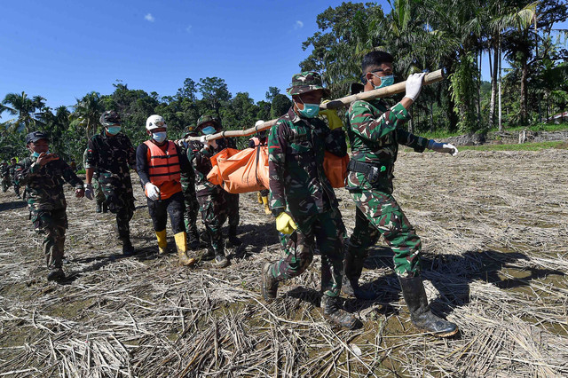 Prajurit Batalyon TP 897/Singgalang dan Brimob Polda Sumbar mengevakuasi korban meninggal akibat banjir bandang di Jorong Kayu Pasak Selatan, Nagari Salareh Aia, Palembayan, Agam, Sumatera Barat, Senin (1/12/2025). Foto: Wahdi Septiawan/ANTARA FOTO