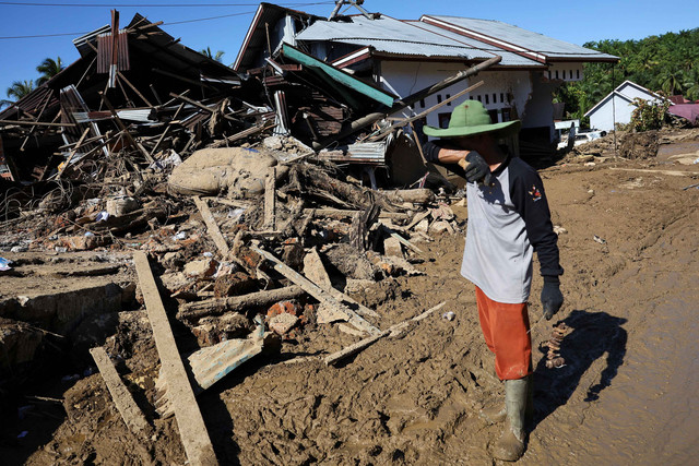 Seorang warga setempat, Syafrizal (62) menangis saat mengunjungi rumah orang tuanya yang ambruk setelah dilanda banjir bandang yang mematikan akibat hujan deras di Palembayan, Kabupaten Agam, Provinsi Sumatera Barat, Senin (1/12/2025). Foto: Willy Kurniawan/REUTERS