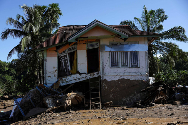 Sebuah rumah yang rusak berat berdiri di area yang dilanda banjir bandang mematikan setelah hujan deras di Palembayan, Kabupaten Agam, Provinsi Sumatera Barat, Senin (1/12/2025). Foto: Willy Kurniawan/REUTERS
