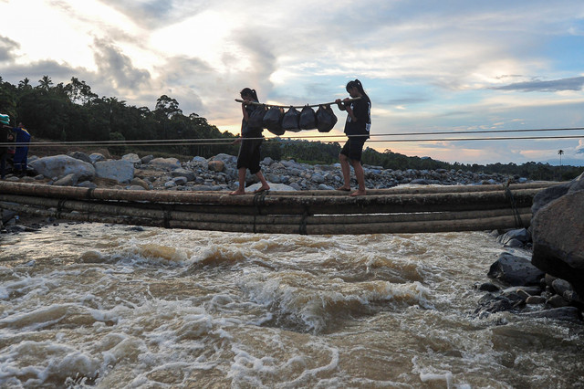 Warga menyeberangi jembatan darurat di atas aliran Sungai Nanggang di Nagari Salareh Aia Timur, Palembayan, Agam, Sumatera Barat, Minggu (30/11/2025). Foto: Wahdi Septiawan/ANTARA FOTO