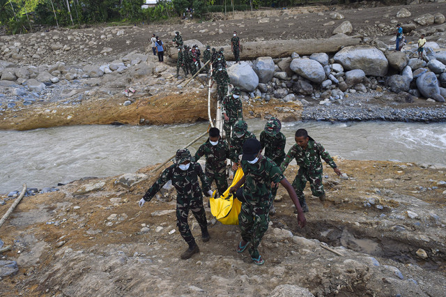 Prajurit Batalyon TP 897/Singalang menggotong jenazah korban meninggal akibat banjir bandang di Nagari Salareh Aia Timur, Palembayan, Agam, Sumatera Barat, Senin (1/12/2025). Foto: Wahdi Septiawan/ANTARA FOTO
