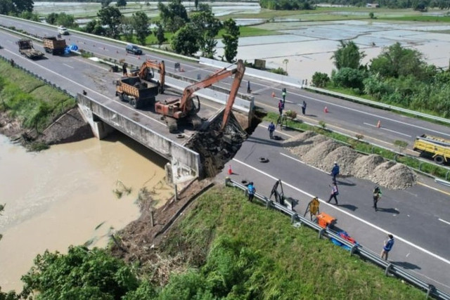 Petugas dengan menggunakan alat berat melakukan perbaikan cepat Ruas Tol Medan-Kualanamu-Tebing Tinggi yang terdampak imbas bencana banjir di Medan. Foto: Aji Cakti/ANTARA