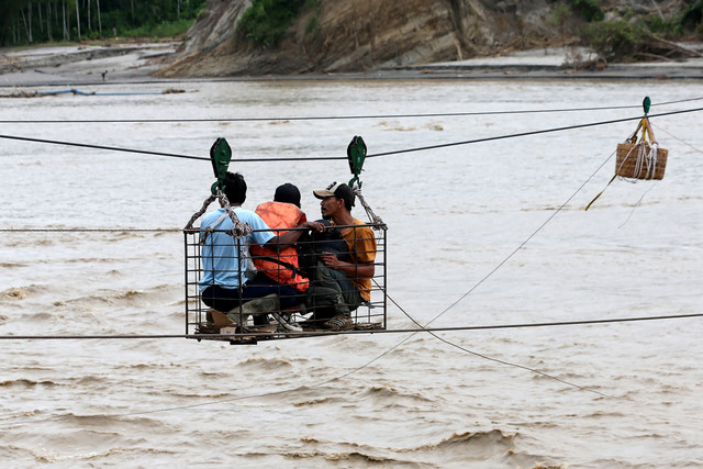Warga menggunakan kabel baja yang untuk menyeberangi Sungai Juli pascaputusnya Jembatan Juli di jalan lintas Bireuen - Takengon, Aceh, Selasa (2/12/2025). Foto: Irwansyah Putra/ANTARA FOTO