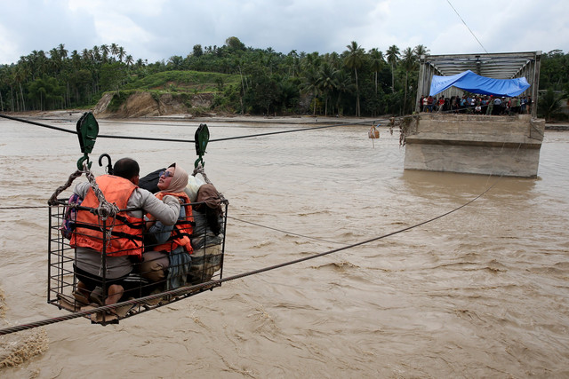 Warga menggunakan kabel baja yang untuk menyeberangi Sungai Juli pascaputusnya Jembatan Juli di jalan lintas Bireuen - Takengon, Aceh, Selasa (2/12/2025). Foto: Irwansyah Putra/ANTARA FOTO