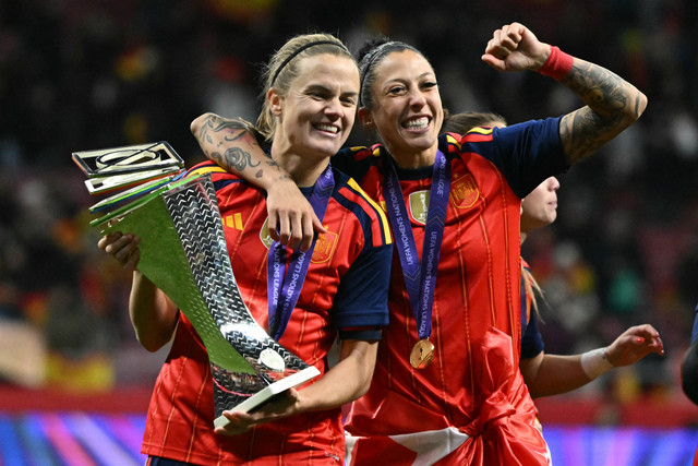 Bek Spanyol Irene Paredes (kiri) dan penyerang Spanyol Jennifer Hermoso merayakan kemenangan dengan trofi setelah memenangkan pertandingan leg kedua final Liga Negara Wanita UEFA antara Spanyol vs Jerman di Stadion Metropolitano, Selasa (12/12/2025). Foto: Javier Soriano/AFP