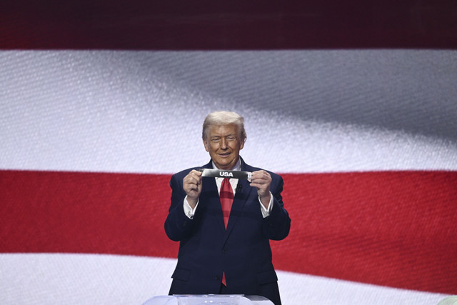 Presiden Amerika Serikat Donald Trump menunjukkan kertas undian saat pengundian Piala Dunia 2026 di Washington DC, Amerika Serikat, Jumat (5/12/2025). Foto: Brendan Smialowski/AFP