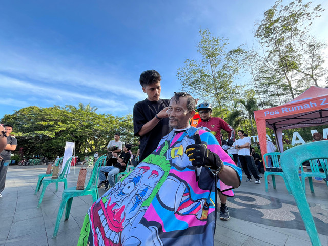 Capster sedang memotong rambut di Bundaran Digulis Untan. Foto: Rabiansyah/Hi!Pontianak