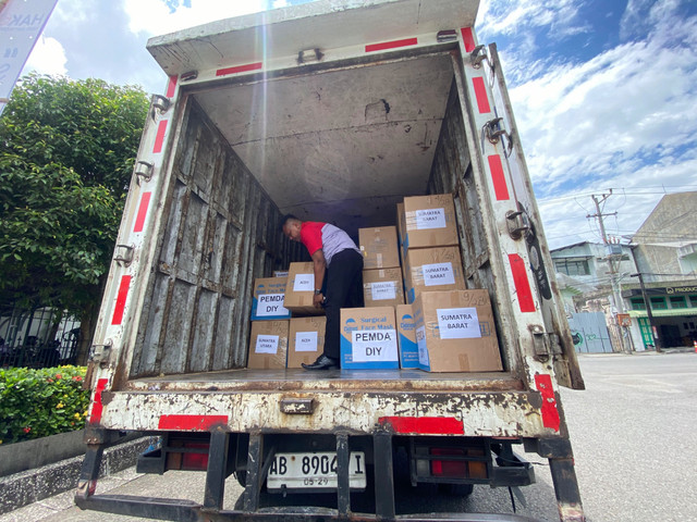 Petugas memuat kotak-kotak berisi bantuan obat-obatan ke dalam truk. Total bantuan yang dikirim oleh Pemda DIY mencapai 842 kilogram. Foto: Pandangan Jogja/Resti Damayanti