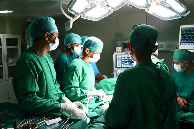 Tim medis Satgas TNI AL melakukan operasi bedah darurat kepada warga terdampak bencana di KRI dr. Radjiman Wedyodininggrat-992 (RJW-992), Dermaga Pelindo Sibolga, Minggu (7/12/2025). Foto: Dispenal