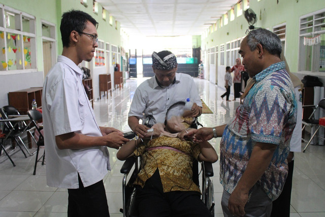 Dr Achmad Arifin ST MEng (kanan) saat mencoba simulasi penggunaan TENS dan NMES pada salah satu penyandang cerebral palsy di Yayasan Pendidikan Autis Mutiara Hati Sidoarjo. Dok. ITS