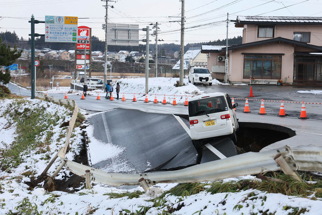 Sebuah kendaraan terparkir di tepi jalan yang runtuh di Kota Tohoku, Prefektur Aomori, imbas terkena gempa bumi dahsyat, Selasa (9/12/2025). Foto: JIJI PRESS/AFP