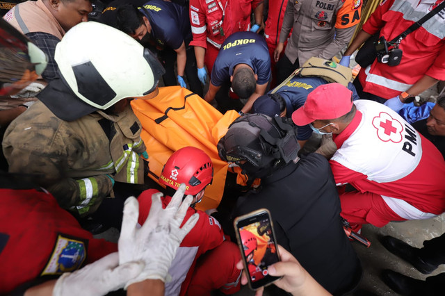 Petugas mengevakuasi korban kebakaran Gedung Terra Drone di Kemayoran, Jakarta Pusat, Selasa (9/12/2025). Foto: Jamal Ramadhan/kumparan