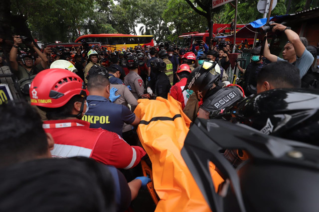 Petugas mengevakuasi korban kebakaran Gedung Terra Drone di Kemayoran, Jakarta Pusat, Selasa (9/12/2025). Foto: Jamal Ramadhan/kumparan