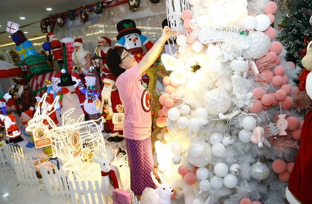 Sujani, salah seorang pedagang merapikan pohon natal dengan hiasan Pink dan hologram karyanya. Foto-foto : Dipta Wahyu