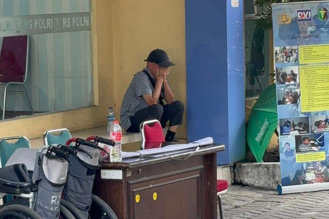 Endang ayah korban kebakaran gedung Terra Drone atas nama Ervina menangis di lobi Pos DVI RS Polri saat menunggu identifikasi jenazah anaknya pada Rabu (10/12/2025). Foto: Abid Raihan/kumparan