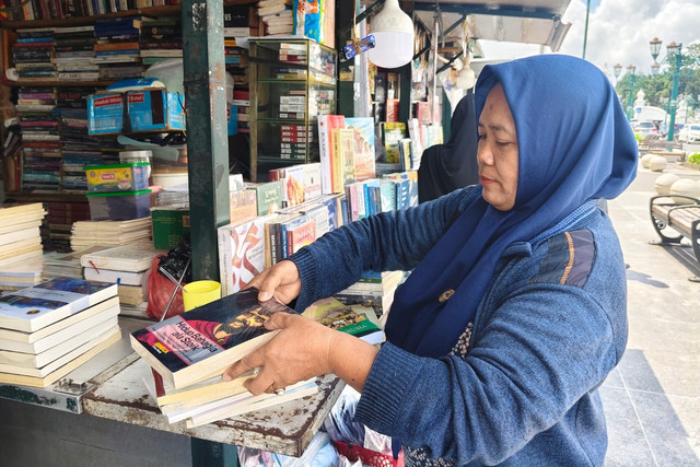 Sumarni, salah satu penjual buku yang tersisa di kios buku kawasan Titik Nol Kilometer Yogyakarta, Kamis (11/12/2025). Foto: Arfiansyah Panji Purnandaru/kumparan