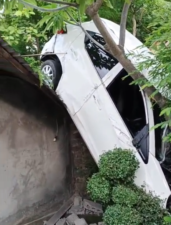 Mobil nyungsep di atap rumah warga, di Buleleng, Rabu (10/12) Foto: Denita br Matondang
