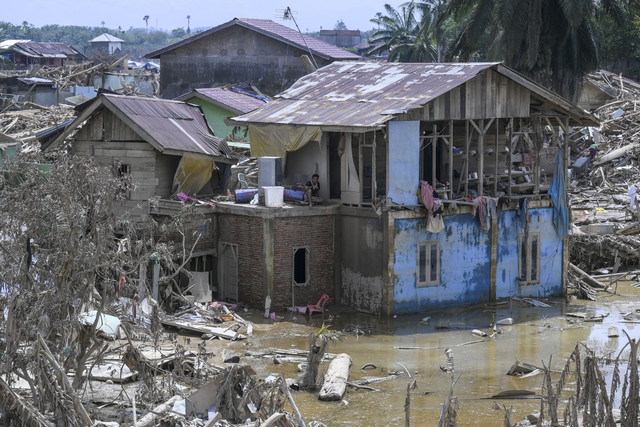 Warga berada di atas rumahnya yang rusak akibat banjir di Kuala Simpang, Aceh Tamiang, Aceh, Kamis (11/12/2025). Foto: Hafidz Mubarak A/ANTARA FOTO