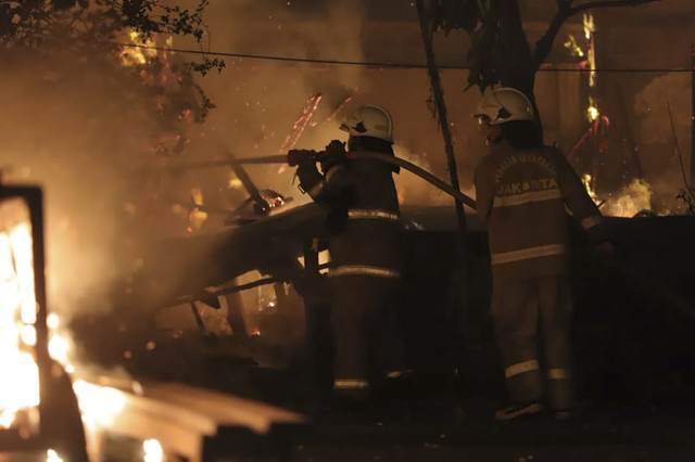 Petugas pemadam kebakaran memadamkan api yang membakar kios saat kericuhan di depan Taman Makam Pahlawan (TMP) Kalibata, Jakarta, Kamis (11/12/2025). Foto: Jamal Ramadhan/kumparan