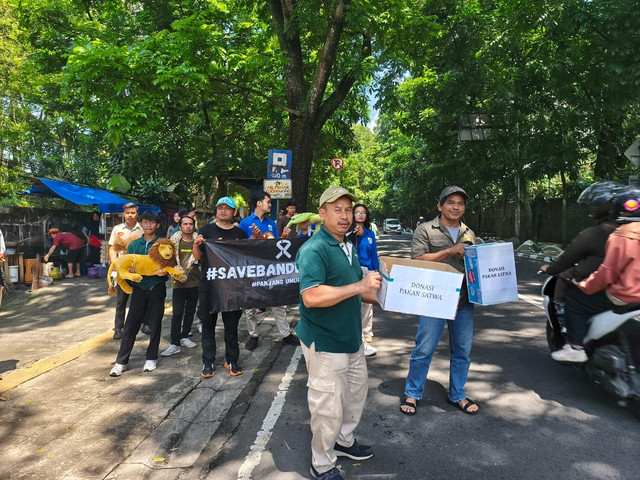 Karyawan Bandung Zoo lakukan aksi galang donasi pakan satwa di Jalan Tamansari, Jumat (12/12). Foto: Linda/kumparan