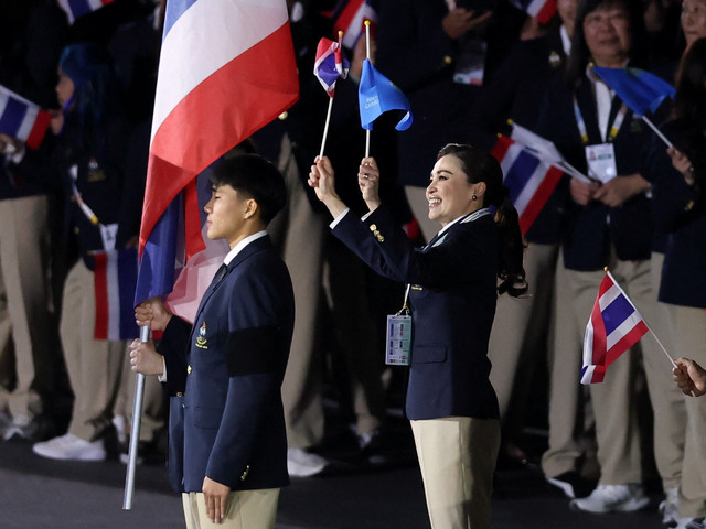 Kontingen Thailand, dipimpin oleh Ratu Suthida, pembawa bendera Janjaem Suwannapheng , Kunlavut Vitidsarn dan pembawa plakat Suchata Chuangsri, selama parade negara-negara pada upacara pembukaan. Foto: REUTERS/Patipat Janthong