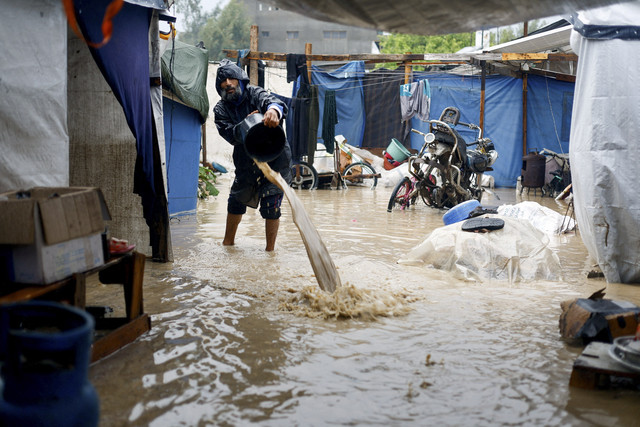 Warga Palestina membuang air yang masuk ke dalam tenda pengungsian akibat banjir di Nuseirat, Jalur Gaza Tengah, Jumat (12/12/2025). Foto: Mahmoud Issa/REUTERS