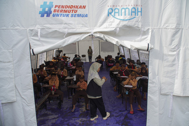 Guru memberi arahan sebelum Asesmen Sumatif Akhir Semester (ASAS) di sekolah darurat bencana erupsi Gunung Semeru di Kecamatan Pronojiwo, Lumajang, Jawa Timur, Sabtu (13/12/2025). Foto: Irfan Sumanjaya/ANTARA FOTO