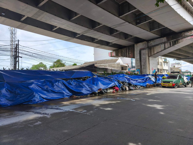 Kondisi tumpukan sampah  yang ditutupi terpal di bawah Flyover Ciputat. Foto: kumparan