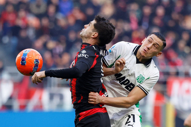 Pemain AC Milan Christian Pulisic berebut bola dengan pemain Sassuolo Jay Idzes pada pertandingan Liga Italia di San Siro, Milan, Italia, Minggu (14/12/2025). Foto: Alessandro Garofalo/REUTERS