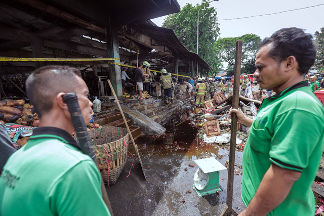 Petugas pemadam kebakaran menyisir area terdampak kebakaran di Pasar Induk Kramat Jati, Jakarta Timur, pada Senin (15/12/2025). Foto: Jamal Ramadhan/kumparan