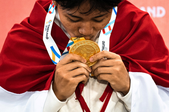 Basral Graito Hutomo mencium medali emas usai memenangkan final cabang olahraga skateboard jalanan putra SEA Games 2025 Thailand di SAT Extreme Sports Park, Bangkok, Thailand, Senin (14/12/2025). Foto: Chanakarn Laosarakham / AFP