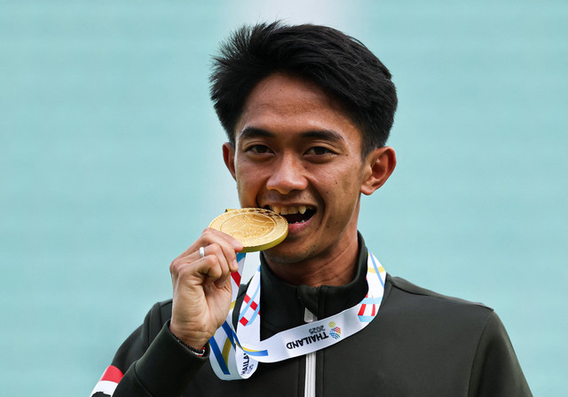Peraih medali emas dari Indonesia, Robi Syianturi, merayakan di podium saat upacara pemberian medali maraton putra SEA Games 2025 di Bangkok, Thailand, Senin (15/12/2025). Foto:  PATIPAT JANTHONG/REUTERS 