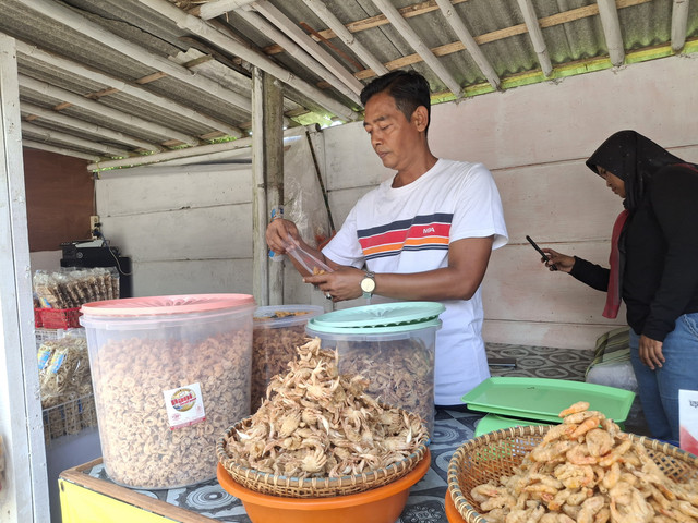 Kegiatan Pak Dani saat membungkusi dagangan untuk melayani pembeli (sudah izin)