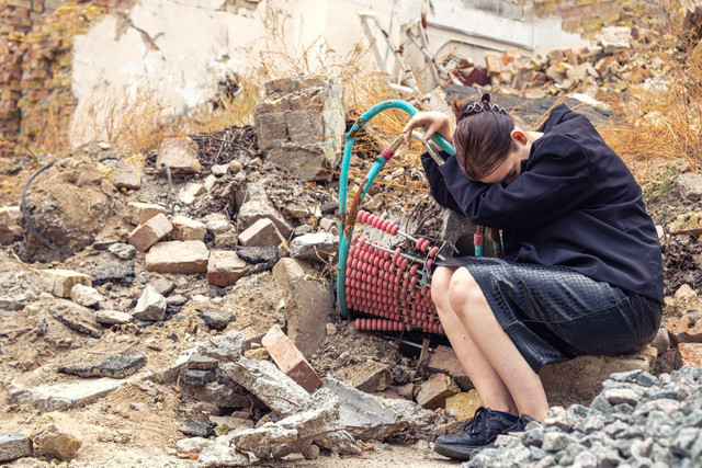 Girl in house destroyed by war in Ukraine
