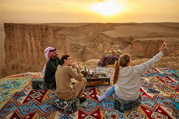 Wanita muda berfoto selfie dengan pria dan pemandu Saudi Foto by Istock