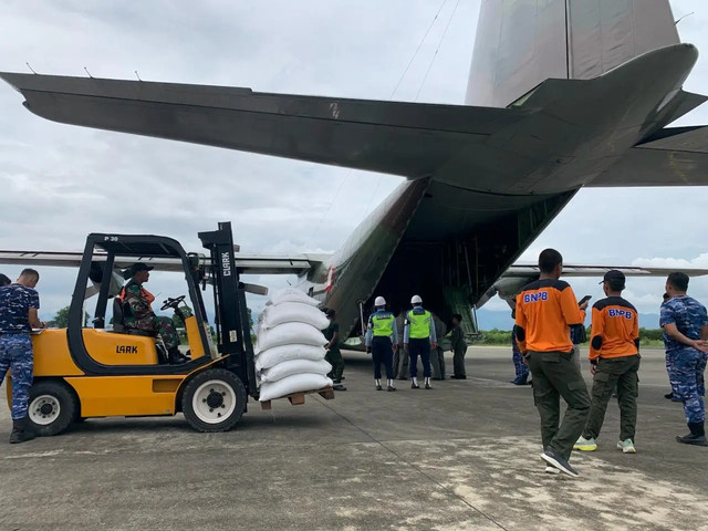 Tim gabungan menyiapkan beras untuk dimasukkan ke pesawat Hercules TNI AU yang akan diterbangkan ke Kabupaten Bener Meriah, pada Jumat (12/12). (Sumber: BNPB)