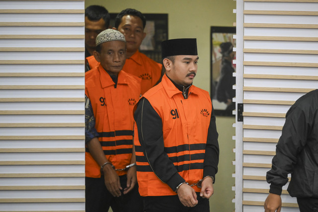 Bupati Bekasi Ade Kuswara Kunang bersama ayahnya H. M. Kunang (kiri) dan pihak swasta Sarjan mengenakan rompi tahanan dihadirkan saat konferensi pers usai terjaring operasi tangkap tangan di Gedung Merah Putih KPK, Jakarta, Sabtu (20/12/2025). Foto: Hafidz Mubarak A/ ANTARA FOTO