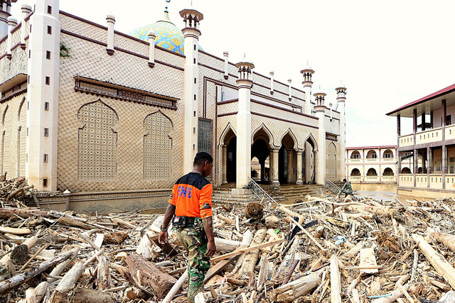 Prajurit TNI berjalan di atas tumpukan kayu di halaman Masjid Pesantren Islam Terpadu Darul Mukhlishin di Desa Tanjung Karang, Aceh Tamiang, Aceh, Jumat (19/12/2025). Foto: ANTARA FOTO/Irwansyah Putra