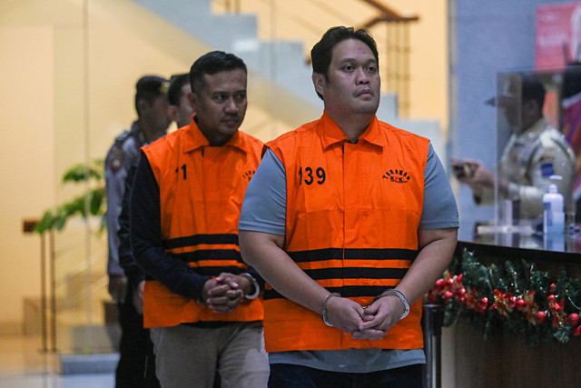 Kajari Hulu Sungai Utara Albertinus Parlinggoman Napitupulu (kanan) bersama Kasi Intel Asis Budianto (kiri) berjalan mengenakan rompi tahanan usai terjaring OTT di Gedung Merah Putih KPK, Jakarta, Sabtu (20/12/2025). Foto: ANTARA FOTO/Hafidz Mubarak A