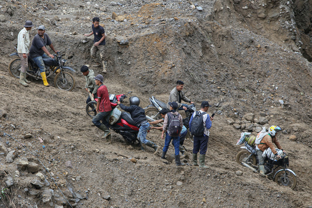 Warga mengangkat sepeda motor saat menyeberangi sungai wilayah Tenge Besi, Kecamatan Pintu Rime Gayo, Kabupaten Bener Meriah, Aceh, Sabtu (20/12/2025).  Foto: ANTARA FOTO/Khalis Surry